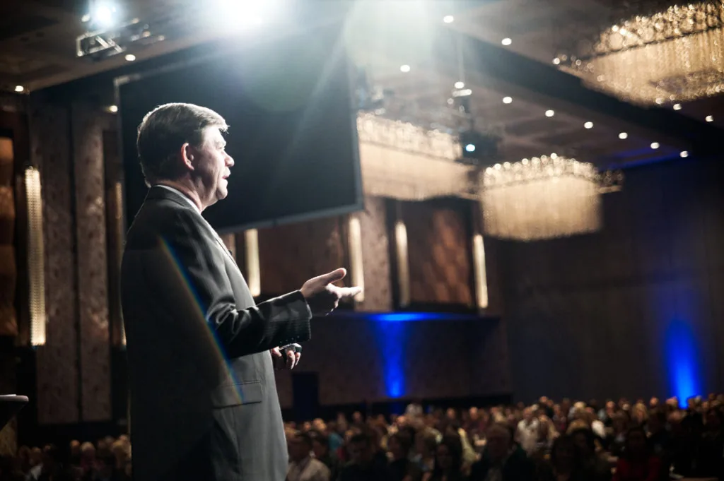 Doug Sleeter on stage before a full conference hall, 2011